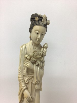 Lot 13 - Large 19th century Japanese ivory tusk figure of a woman, shown wearing a long robe and holding flowers, on a wooden base, total height 46cm