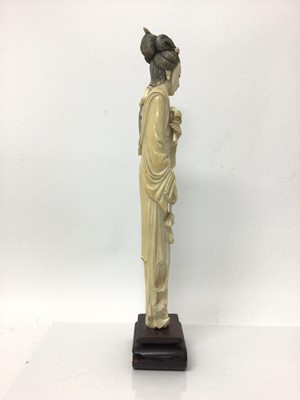 Lot 13 - Large 19th century Japanese ivory tusk figure of a woman, shown wearing a long robe and holding flowers, on a wooden base, total height 46cm