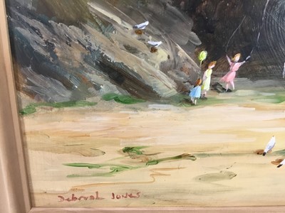 Lot 29 - Deborah Jones (d. 2012 ) oil on board - Children playing on a beach below cliffs, signed, 29cm x 39cm