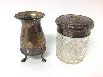 Lot 136 - 1920s silver tea cup with engraved monogram, silver sauce boat, silver vase raised on three legs and silver topped glass jar