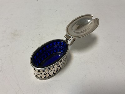 Lot 124 - Edwardian silver mustard pot of oval form, with pierced decoration and blue glass liner, (London 1906), 9.5cm in length.