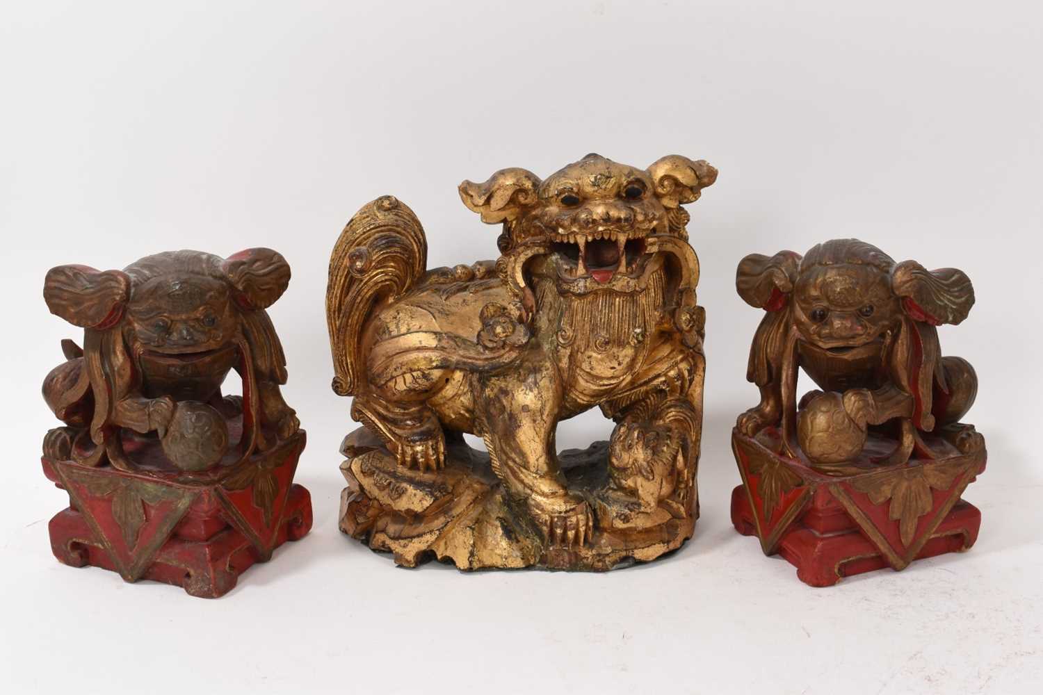 Lot 874 - Antique Chinese carved gilt Buddhist lion and pair of carved guardians