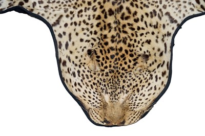 Lot 873 - Early 20th century Leopard skin rug on black backing, nose to tail 257cm, paw to paw 174cm