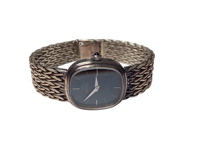 Lot 52 - Omega De Ville ladies silver wristwatch with a navy dial and silver baton markers, on a woven silver strap (London import mark, 1975), in original box with booklets
