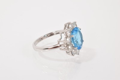 Lot 51 - Blue topaz and diamond cluster ring with an oval mixed cut blue topaz surrounded by ten brilliant cut diamonds
