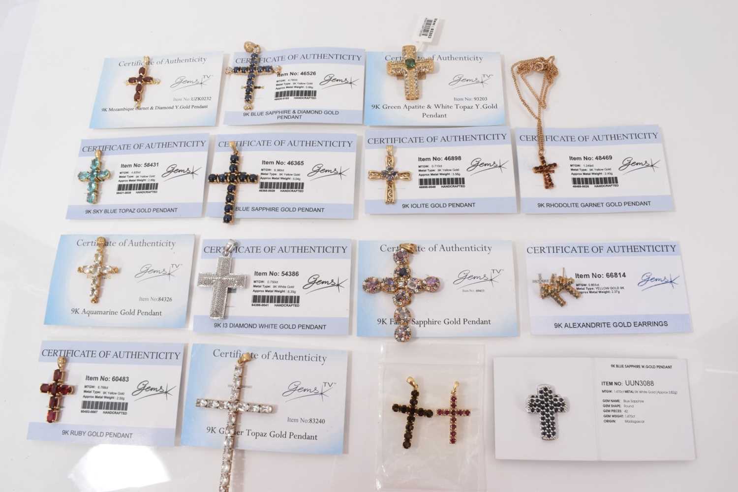 Lot 12 - Fifteen 9ct gold gem set cross pendants, one on 9ct gold chain and pair of 9ct gold gem set cross earrings, mostly with Gems TV certificates