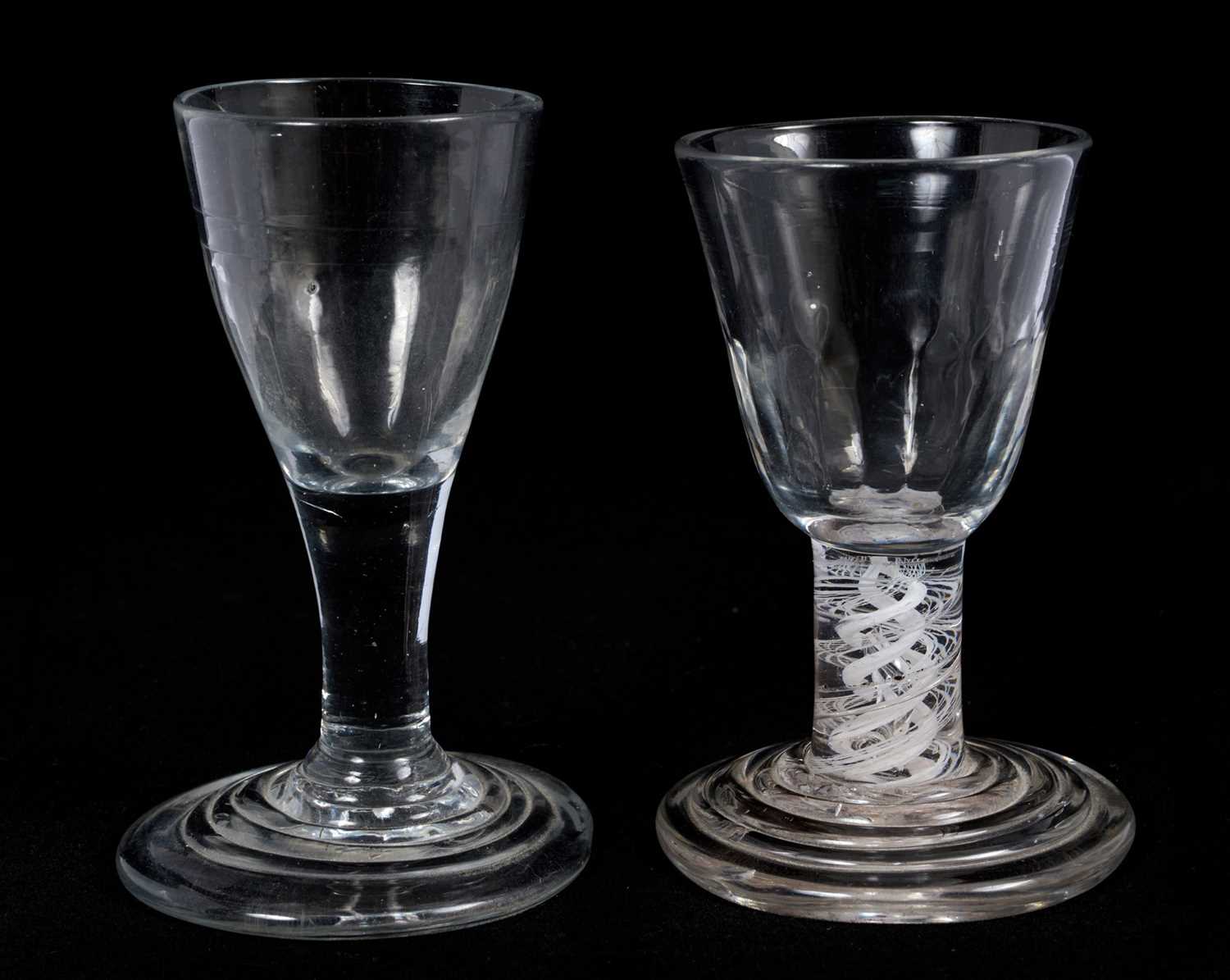 Lot 66 - 18th century firing glass, with fluted round funnel bowl, double series opaque twist stem, and stepped foot, together with another firing glass with fluted bowl and stepped foot, 10cm and 10....