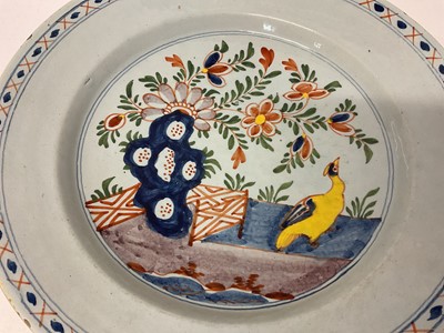 Lot 130 - Two 18th century Delft dishes, polychrome painted in the Chinese style with fence patterns, one with a bird, 35cm and 34.5cm diameter