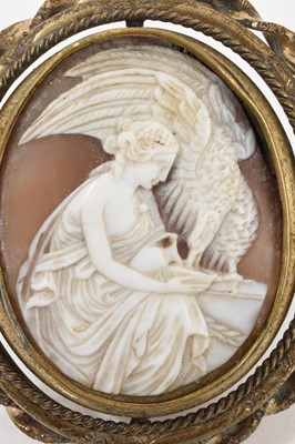 Lot 522 - 19th century Italian carved shell cameo depicting Hebe, Greek goddess of youth feeding an eagle, in a gilt metal revolving brooch mount with glazed portrait to the reverse