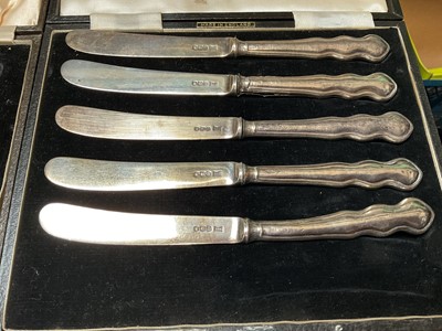 Lot 122 - Five 1930s silver butter knives, various silver spoons and a Continental silver (800) cream jug with engraved decoration