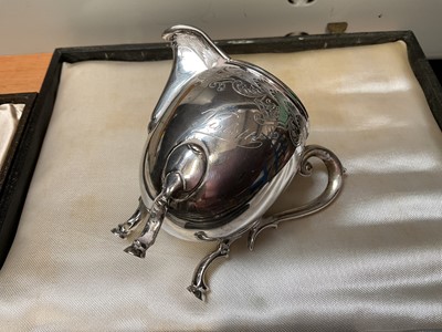 Lot 122 - Five 1930s silver butter knives, various silver spoons and a Continental silver (800) cream jug with engraved decoration