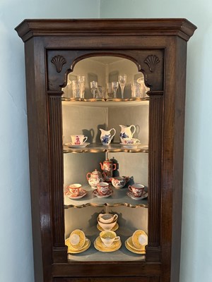Lot 1255 - Antique mahogany two-height corner cupboard, painted interior with three shaped shelves above a single cupboard below, 197cm high