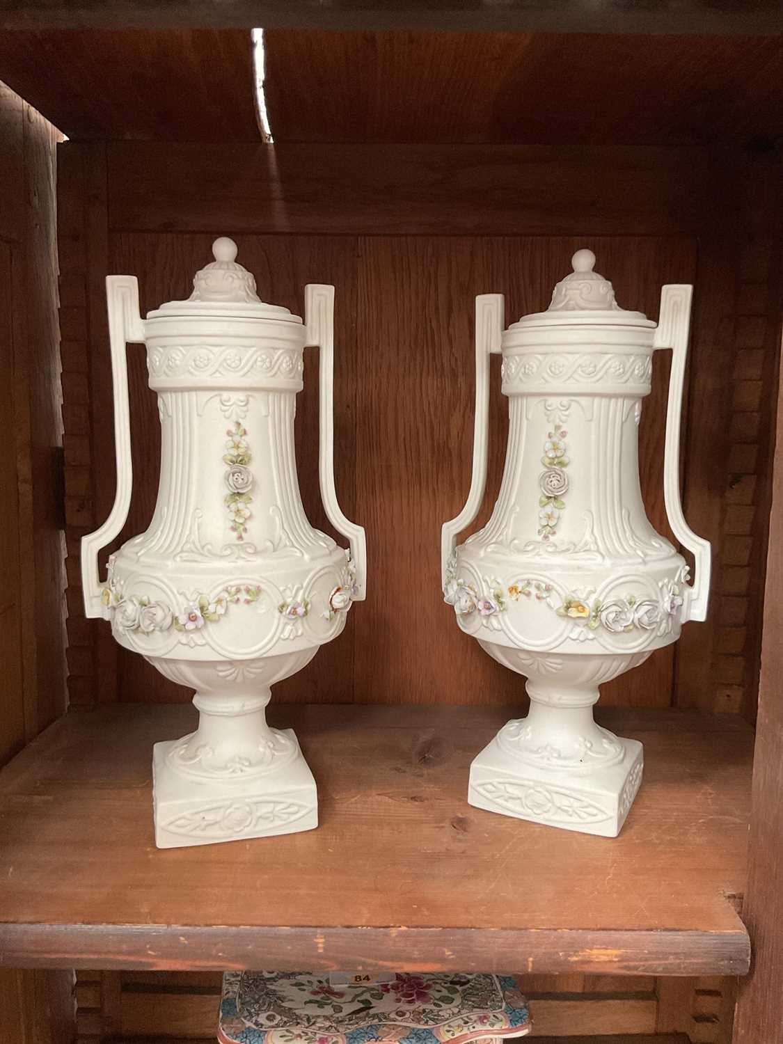 Lot 90 - Pair of antique bisque lidded urns with applied floral garlands