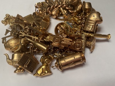 Lot 18 - 9ct gold curb link charm bracelet with padlock clasp extensive collection of 9ct gold and yellow metal novelty charms