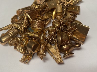 Lot 18 - 9ct gold curb link charm bracelet with padlock clasp extensive collection of 9ct gold and yellow metal novelty charms