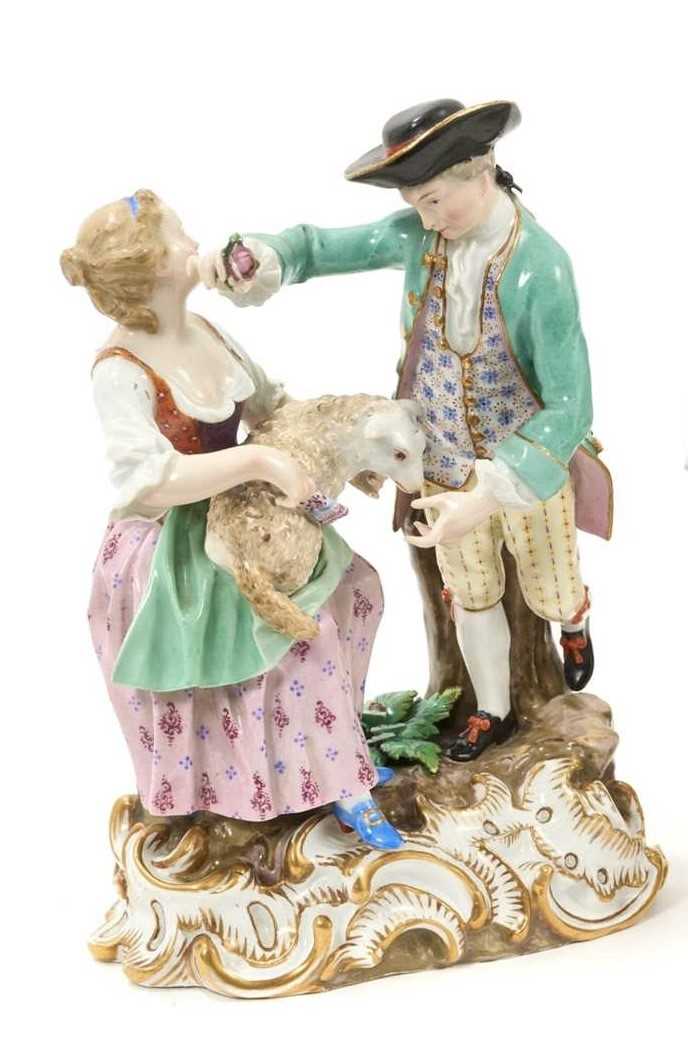 Lot 57 - 18th / 19th century Meissen porcelain group of a couple, the woman seated with a lamb on her lap, the man standing over her with a flower, on a gilt rococo scroll base, crossed swords and incised...
