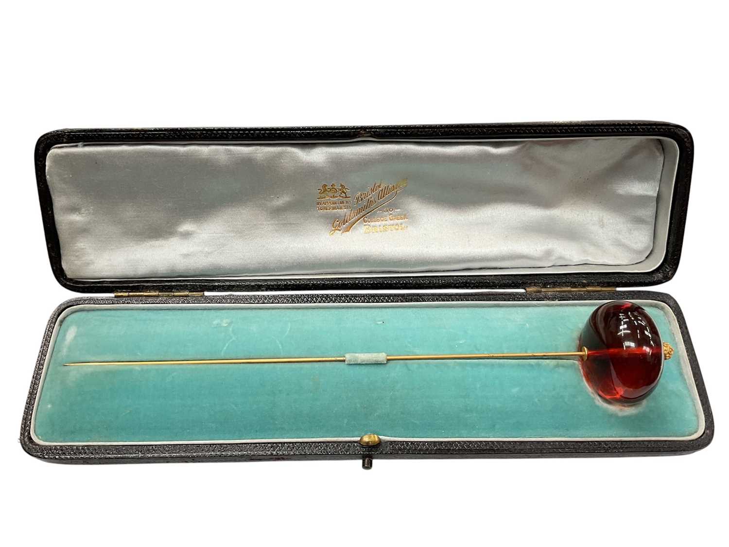 Lot 42 - Victorian amber hat pin with a large polished amber bead terminal on a gilt metal pin, in original fitted case