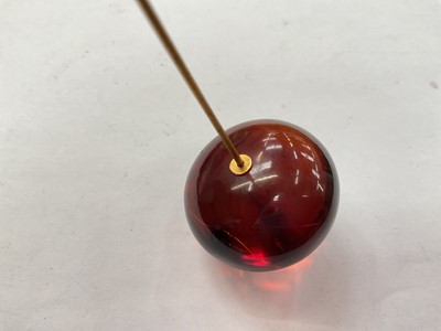 Lot 42 - Victorian amber hat pin with a large polished amber bead terminal on a gilt metal pin, in original fitted case