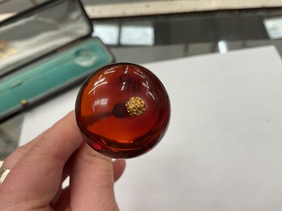 Lot 42 - Victorian amber hat pin with a large polished amber bead terminal on a gilt metal pin, in original fitted case