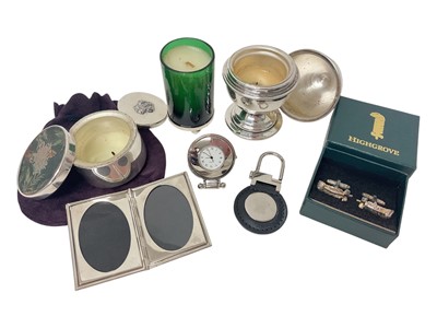 Lot 65 - H.R.H. Prince Charles Prince of Wales, collection of six Christmas gifts comprising three scented candles in silver plated mounts, a keyring , a travelling clock and folding photograph frame all...
