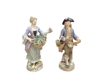 Lot 5038 - Pair of 19th century Meissen figures, holding baskets of flowers and fruit, crossed swords and other marks, both 14cm tall
