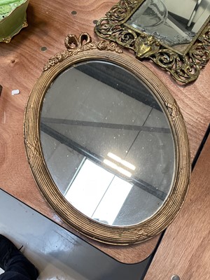 Lot 5090 - Victorian brass easel mirror with mask and scrolling foliage, engraved with a crown and initials, 45cm x 27cm, together with an oval gilt wall mirror (2)