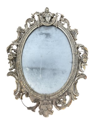 Lot 5180 - Impressive 18th / 19th century carved giltwood wall mirror, oval with cherub cresting and pierced C-scroll surround, A.F., 105 x 75cm