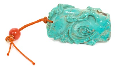 Lot 31 - Formerly the property of William Tallon R.V.M., Antique Chinese carved bluestone pendant of naturalistic trunk form with floral and leaf decoration on silk cord suspension 5.5 x 3cm Sold by thes...