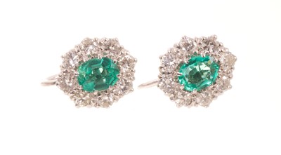 Lot Pair of emerald and diamond cluster earrings, each with an oval mixed cut emerald measuring approximately 5.8 x 4.6mm, surrounded by a border of eight brilliant cut diamonds in white gold claw s...