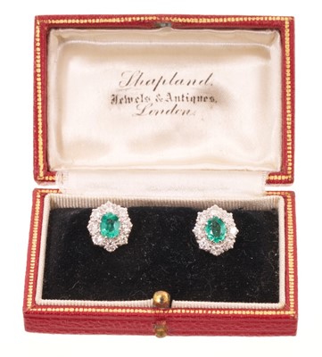 Lot 556 - Pair of emerald and diamond cluster earrings, each with an oval mixed cut emerald measuring approximately 5.8 x 4.6mm, surrounded by a border of eight brilliant cut diamonds in white gold claw s...