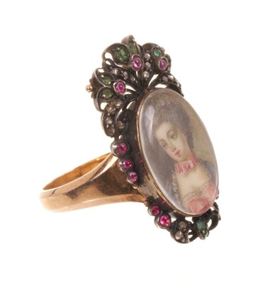 Lot 562 - Antique French ring with a portrait miniature on ivory depicting the bust of a young lady, the oval glazed bezel surmounted by pierced cresting and framed with diamonds, rubies and emeralds, on...