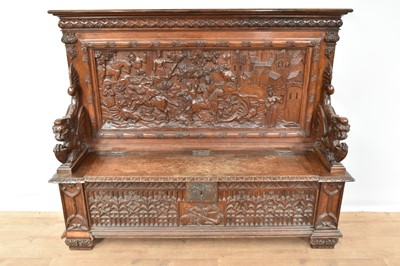 Lot Good 19th century carved oak hall bench, the high back carved in high relief with mediaeval hunting scene and hinged seat flanked by dragon figures, the front with ornate tracery on carved feet,...