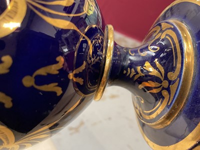 Lot 303 - Five 19th century Coalport porcelain urns, each painted with flowers, one of them on a maroon ground and the others on a cobalt blue ground, 12cm to 19cm high