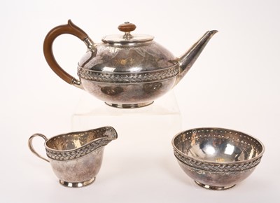 Lot George V silver three piece teaset in the Arts and Crafts style, comprising teapot of circular form, with overall planished decoration, fruitwood scroll handle and finial, engraved vine decorati...
