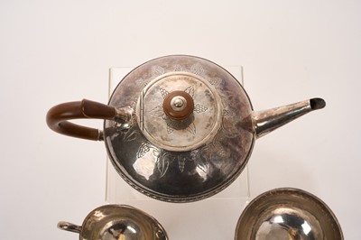 Lot 469 - George V silver three piece teaset in the Arts and Crafts style, comprising teapot of circular form, with overall planished decoration, fruitwood scroll handle and finial, engraved vine decorati...