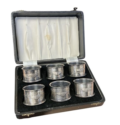 Lot 94 - Set of six 1930s silver plated napkin rings, each mounted with a Bentley winged B logo, in a fitted case