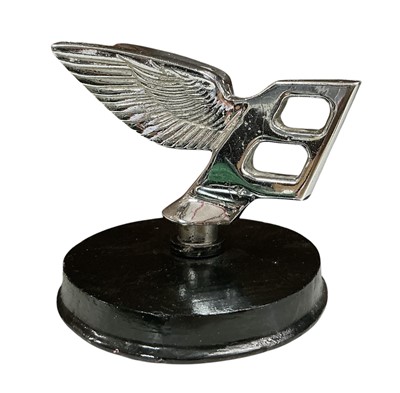Lot 107 - Chromium plated Bentley 'Flying B' car mascot, mounted on a wooden base, 6.5cm in height (excluding base)