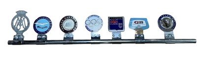 Lot 115 - Group of seven assorted car grill badges, mounted on a badge bar, to include British Olympic Association, Trailer Caravan Club and Maddiesons Holiday Camps Limited