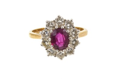 Lot 424 - Ruby and diamond cluster ring with an oval mixed cut ruby surrounded by ten brilliant cut diamonds in 18ct gold setting