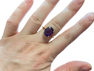 Lot 90 - Amethyst single stone ring with an oval mixed cut amethyst in four claw setting on 18ct yellow gold shank, size L½
