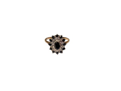 Lot 70 - Sapphire and diamond cluster ring with a central oval mixed cut sapphire, surrounded by a border or diamonds and further round mixed cut sapphires