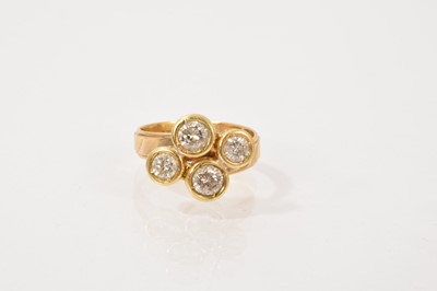 Lot 451 - Diamond four stone ring in a yellow metal rub over setting