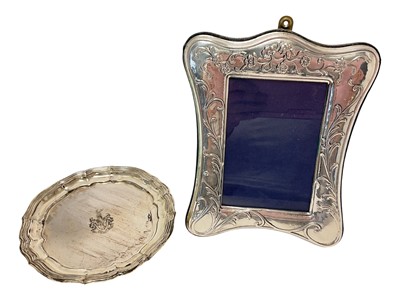 Lot 278 - Silver coaster with pie crust edge, engraved with cost of arms, and silver photo frame. (2)