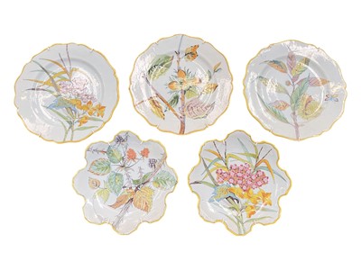 Lot 120 - Five Quimper faience dishes painted with flowers, including three round scalloped plates and two with crenelated rims, the rims each painted yellow