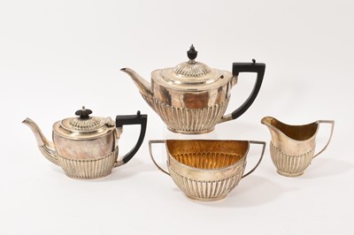 Lot 329 - Two fluted silver teapots, together with a sugar bowl and milk jug, all at 33.77ozs, (4).