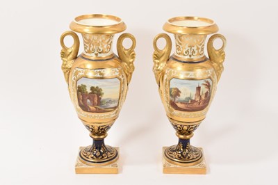 Lot 142 - Pair of early 19th century English porcelain urn shaped vases, mythical beast handles, painted with landscape scenes, on a gilt patterned and cobalt blue ground, 27.5cm high