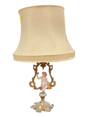 Lot 138 - 19th century gilt brass lamp with a porcelain figure of a putto holding a jug of wine and a glass, 62cm high including shade