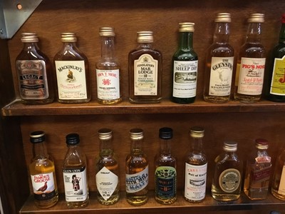 Lot 135 - Collection of miniature spirits in wall cabinet.