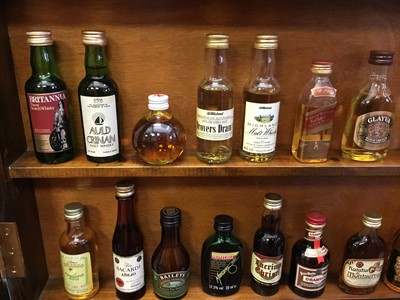 Lot 135 - Collection of miniature spirits in wall cabinet.