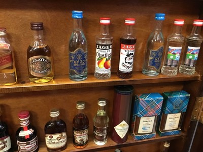 Lot 135 - Collection of miniature spirits in wall cabinet.